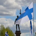 a statue of a person holding a cross and a flag