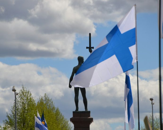 a statue of a person holding a cross and a flag