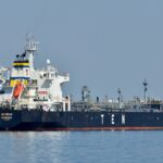 black and white ship on sea under gray sky during daytime