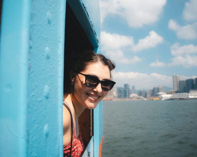 Young woman smiles from a blue window on a boat.