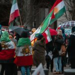 a group of people walking down a street holding flags