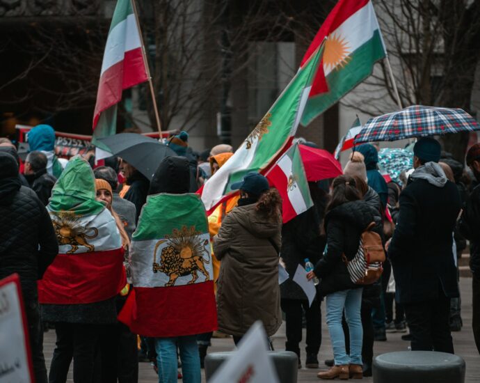 a group of people walking down a street holding flags