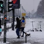 a group of people walking down a snow covered street