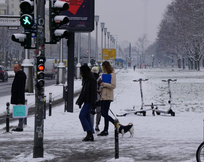 a group of people walking down a snow covered street
