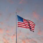 us a flag on pole under cloudy sky