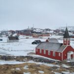 a small red church on a snowy hill