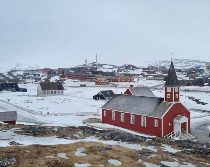 a small red church on a snowy hill