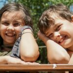 girl in gray sleeveless shirt smiling beside girl in gray sleeveless shirt