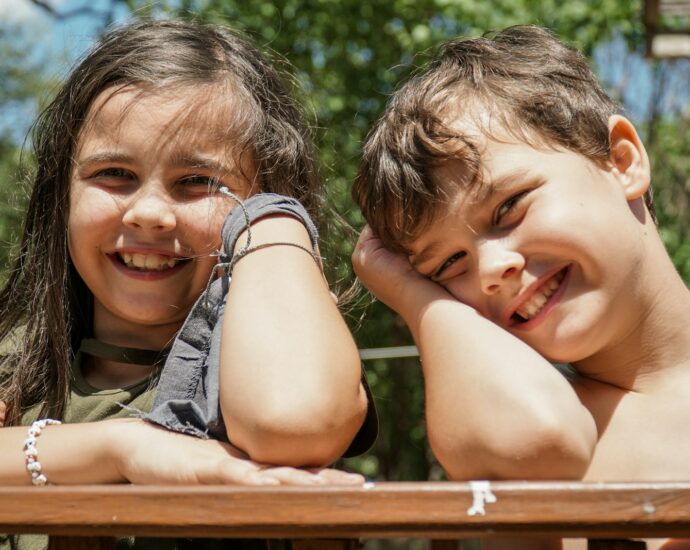 girl in gray sleeveless shirt smiling beside girl in gray sleeveless shirt