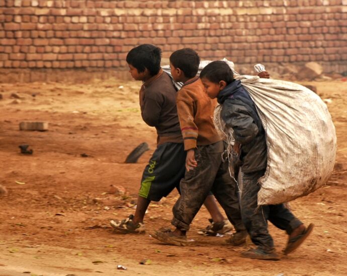 a group of young boys walking down a dirt road