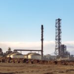 A refinery in a desert setting, showcasing energy production and industrial machinery.