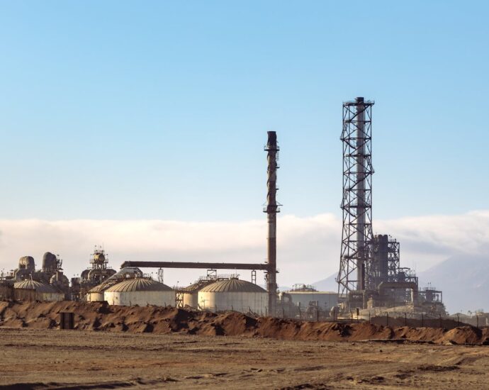 A refinery in a desert setting, showcasing energy production and industrial machinery.