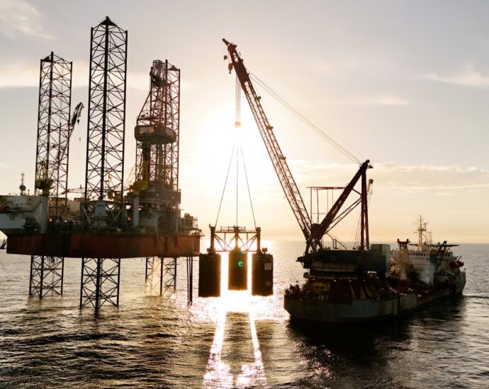 An oil rig being serviced by a supply ship.