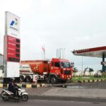 A red tanker truck at a gas station.