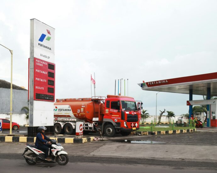 A red tanker truck at a gas station.