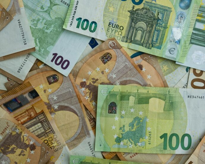 Scattered euro banknotes of 100 and 50 denominations.