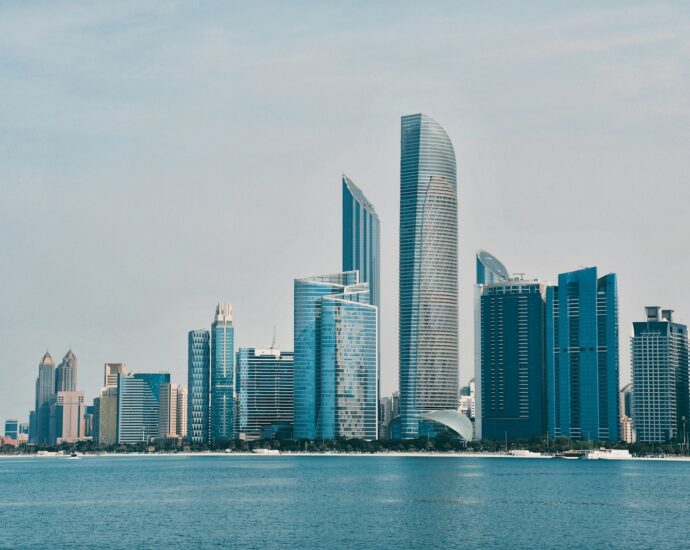 a city skyline with a body of water in the foreground