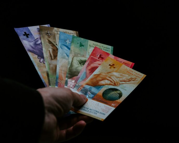 person holding 10 and 20 philippine peso bill