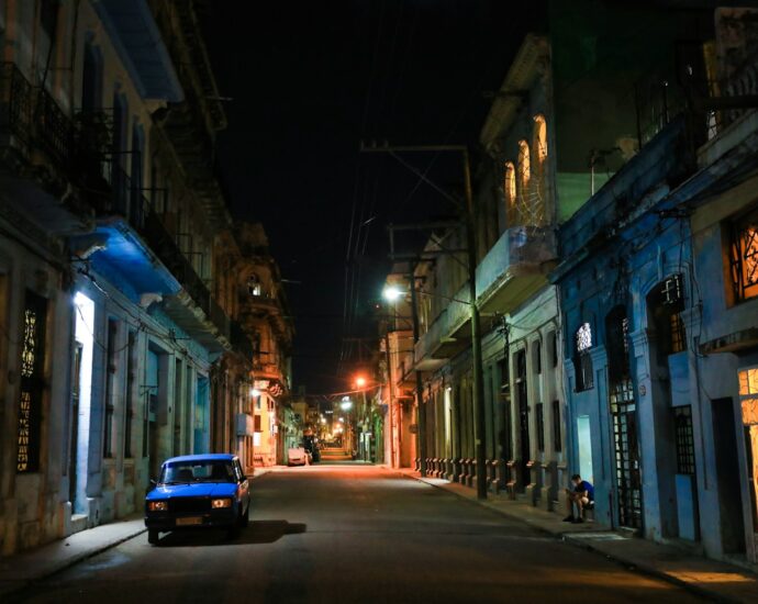 a car parked on the side of a street at night