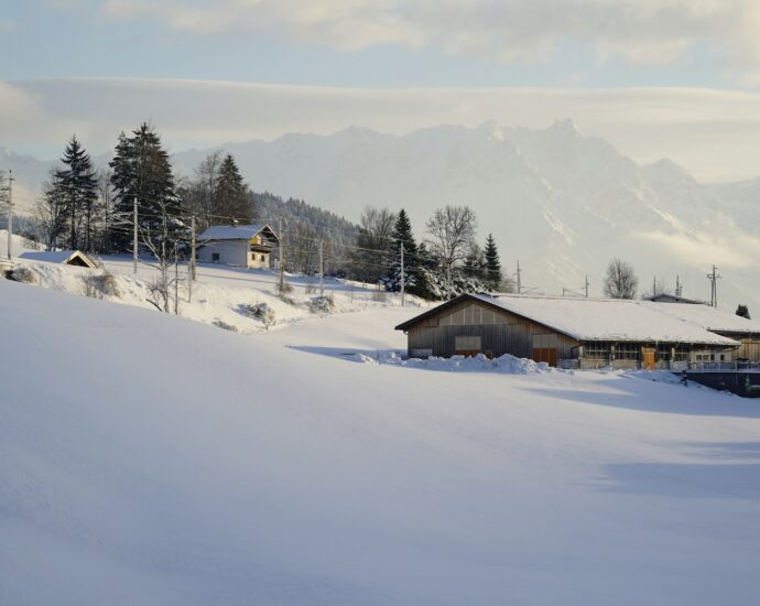 a snow covered hill with a house in the distance