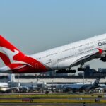 A qantas plane takes off from the runway.