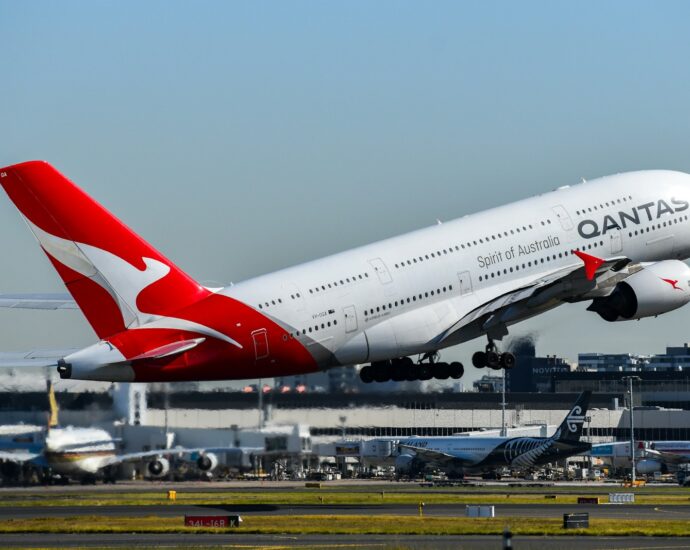 A qantas plane takes off from the runway.