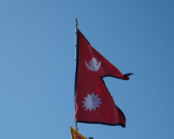 Two flags flying in the wind on a clear day