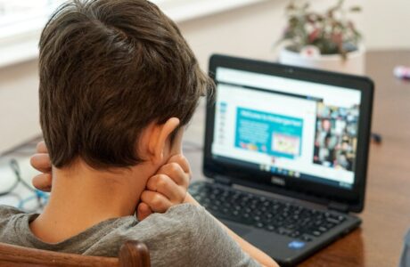 boy in gray shirt using black laptop computer