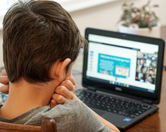 boy in gray shirt using black laptop computer
