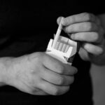 a person holding a cigarette lighter in their hand