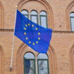 a european flag flying in front of a brick building