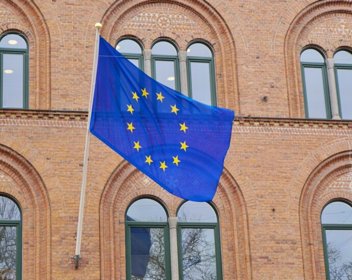 a european flag flying in front of a brick building