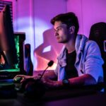 a man sitting in front of a computer monitor