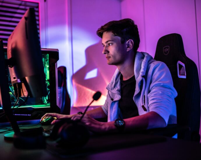 a man sitting in front of a computer monitor