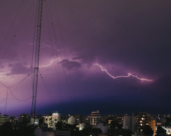 a lightning storm is seen over a city at night