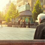 man sitting on brown wooden bench
