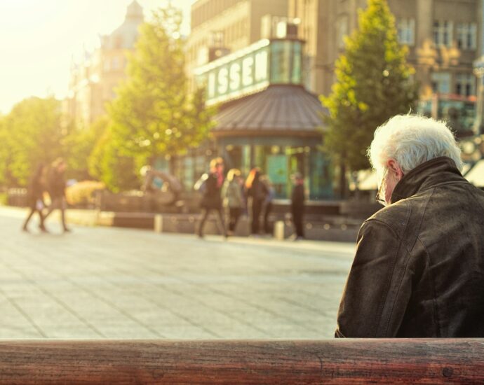 man sitting on brown wooden bench