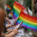 A group of people holding a rainbow flag