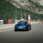 A blue sports car on a highway.