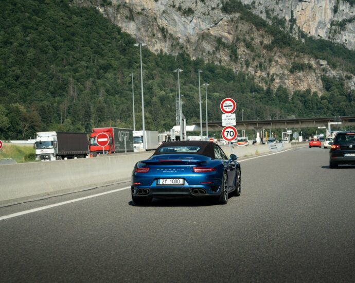 A blue sports car on a highway.