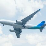 white and blue airplane under white clouds during daytime