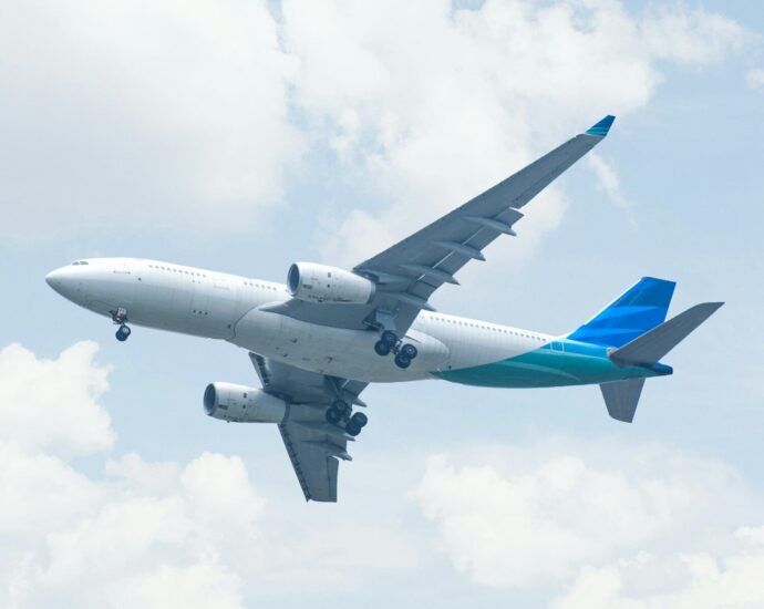 white and blue airplane under white clouds during daytime