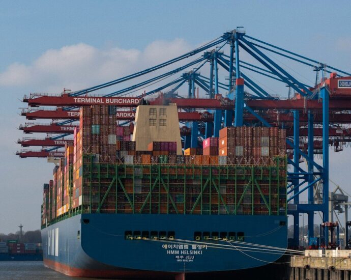 A cargo ship is being unloaded at the harbor.
