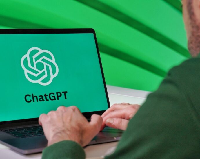 Person typing on a laptop displaying ChatGPT logo with a green vibrant setting.