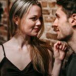 Young man and woman looking at each other enjoying romantic date together in cafe