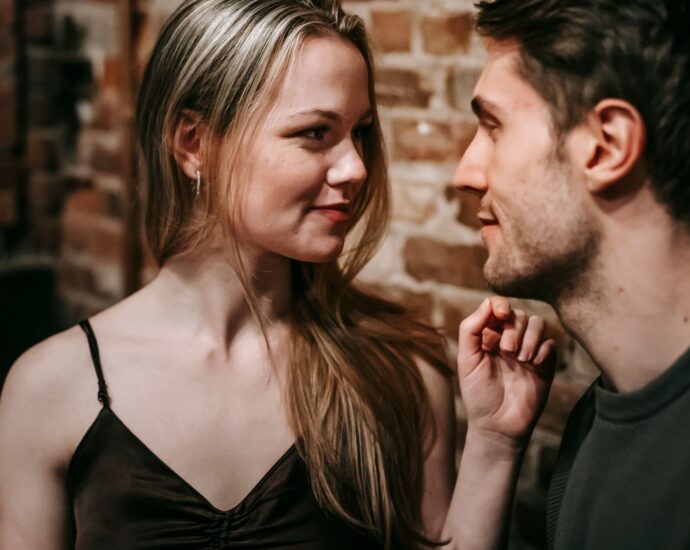 Young man and woman looking at each other enjoying romantic date together in cafe