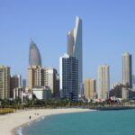 people on beach near high rise buildings during daytime