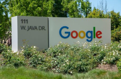 a google sign in front of some bushes and trees