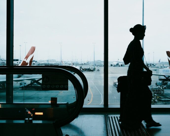 Silhouette of a woman with suitcase at airport