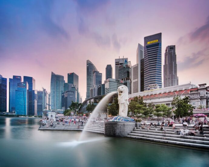 Stunning view of Singapore's skyline featuring the famous Merlion fountain at dusk.